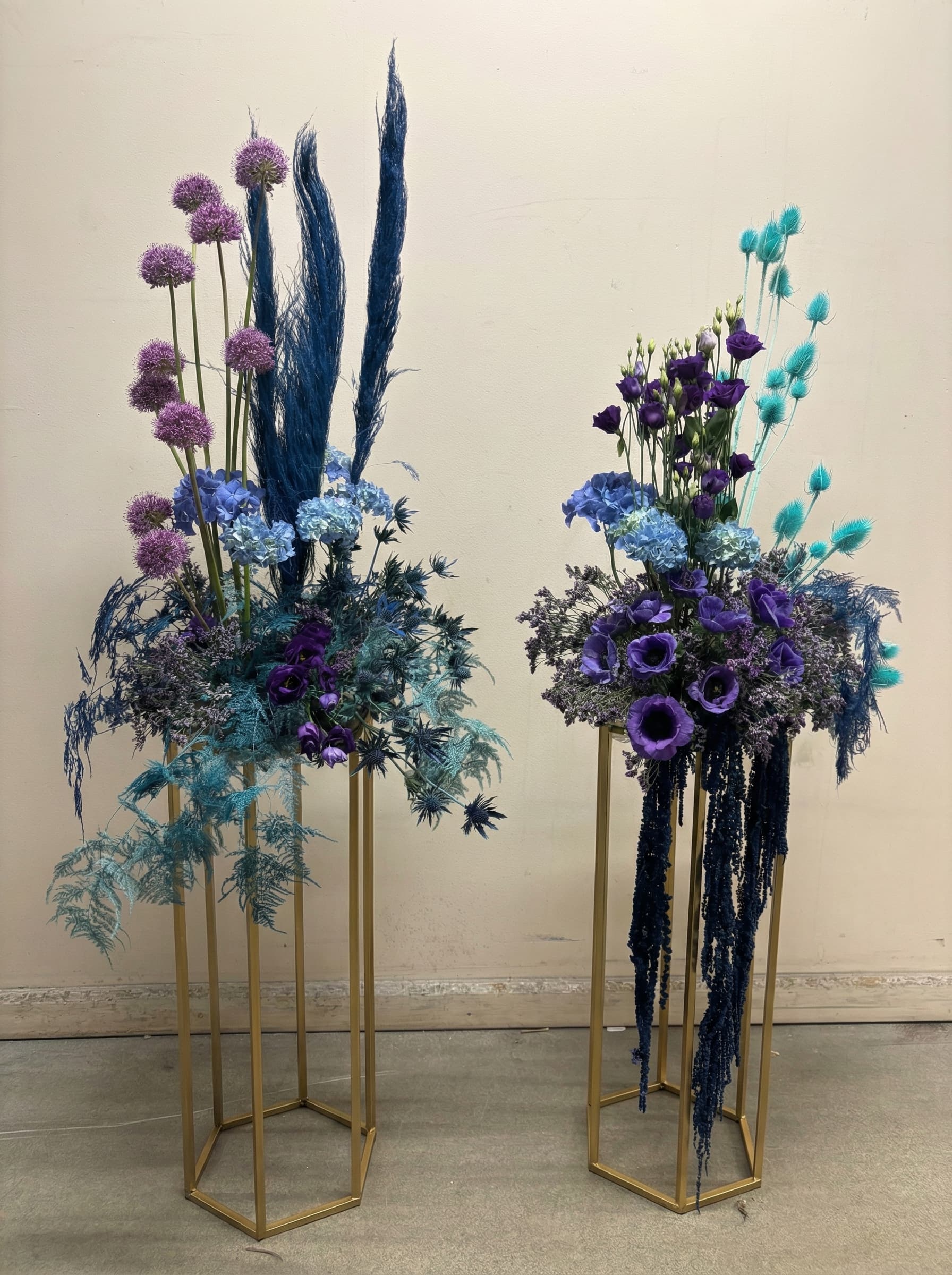 Lila och blå arrangemang på guldstativ