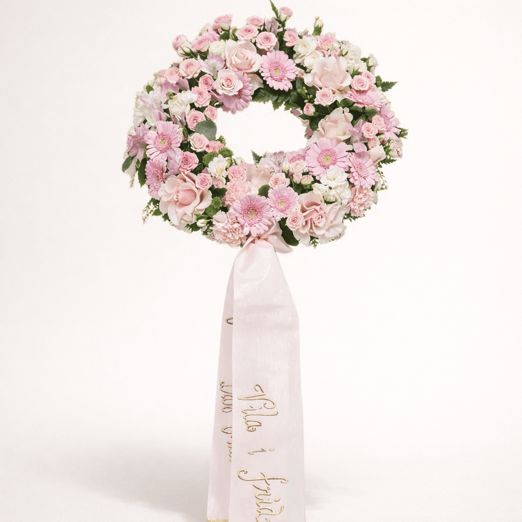 Begravningskrans med rosa band och text