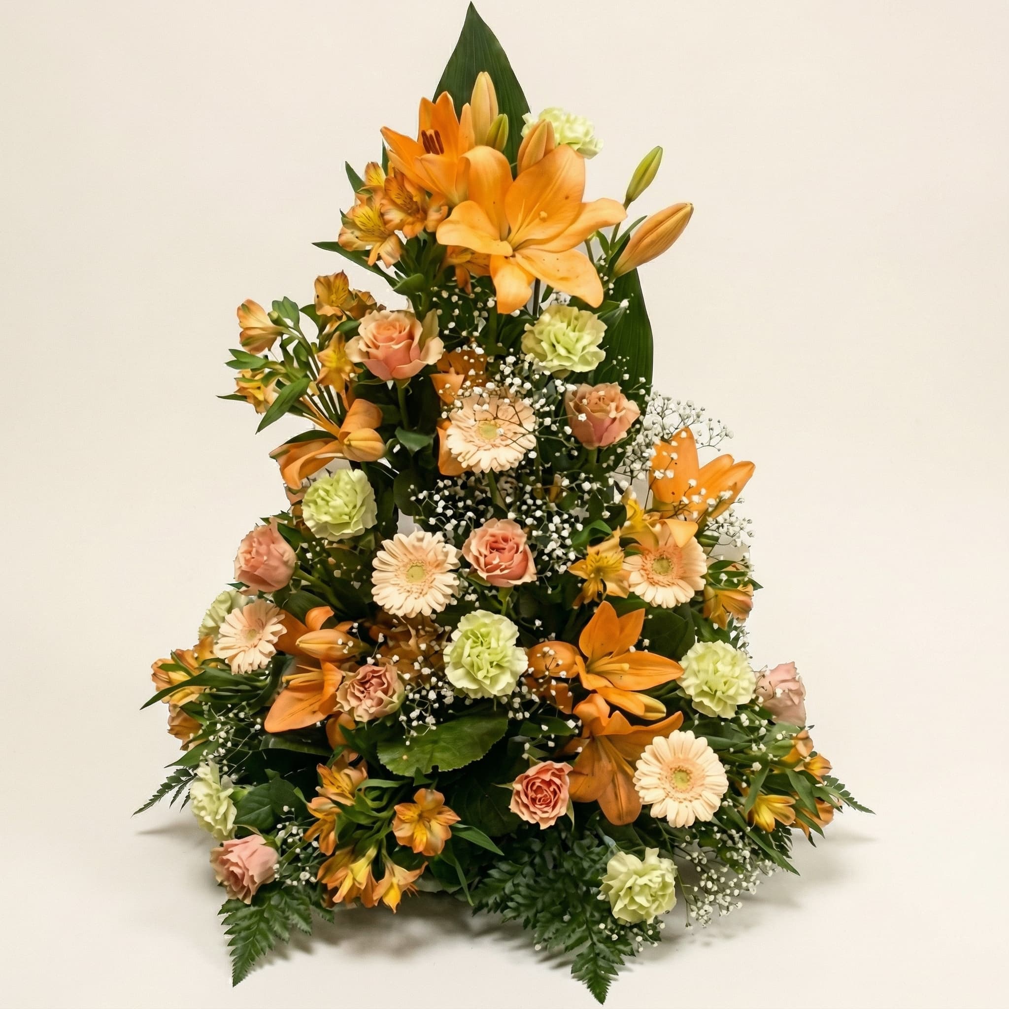 Stående sorgarrangemang med orange liljor